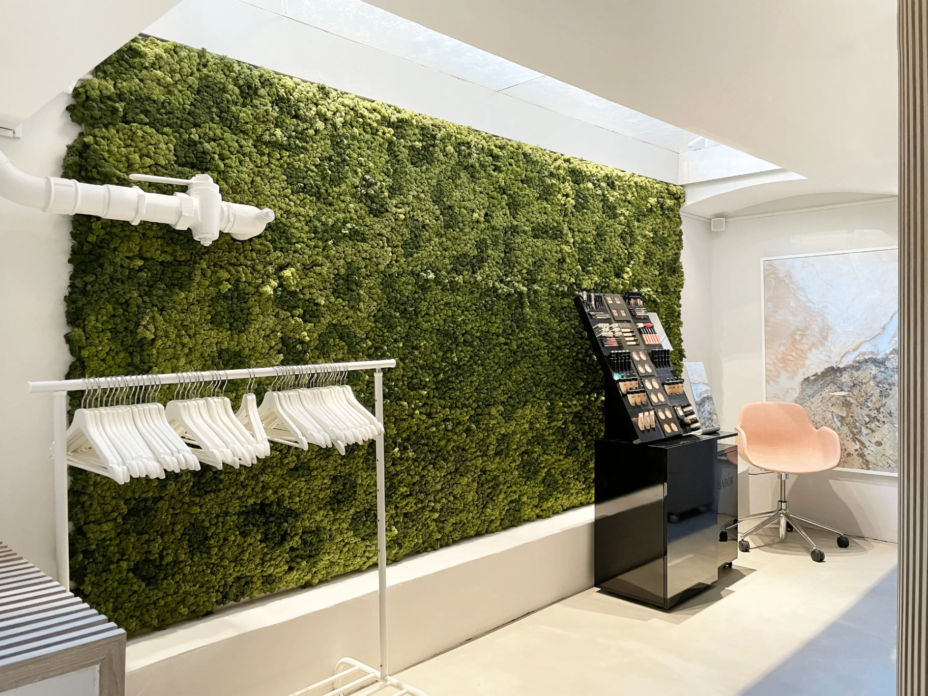 Bright architectural moss feature wall behind modern apparel display